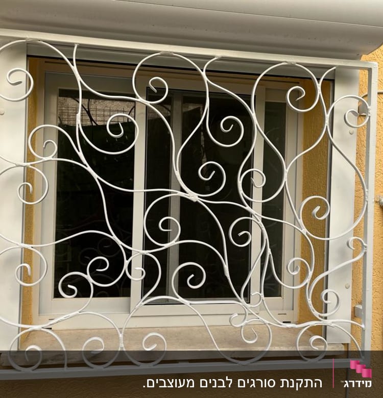 סורגי מתכת לבנים עם עיטורים מעוגלים על חלון